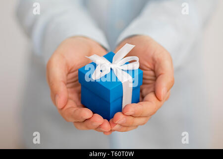 Small blue present box in hands Stock Photo