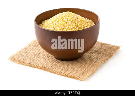 Pile of golden millet, a gluten free grain seed, in wooden bowl on burlap fabric over white background Stock Photo