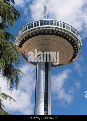 Close-up of the Faro de Moncloa Moncloa Lighthouse transmission tower and observation deck against blue sky and white clouds background. Stock Photo