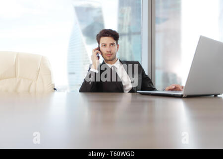 Busy businessman in office working on his laptop Stock Photo