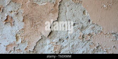 Old grungy weathered wall background texture. Beige dirty peeled plaster wall with falling off flakes of paint Stock Photo
