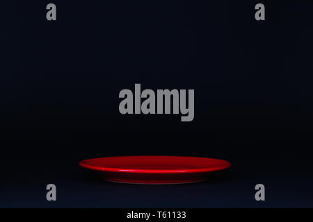 Empty red plate on the black background Stock Photo