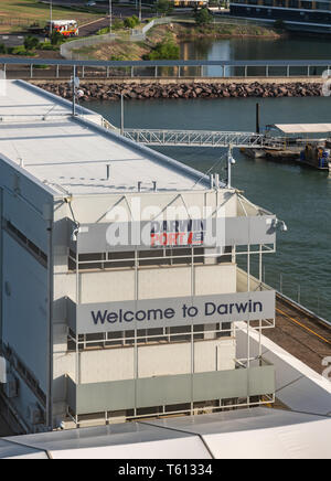 Darwin Australia - February 22, 2019: Closeup of white building of cruise terminal with welcome sign. walk ways and sea water. Stock Photo