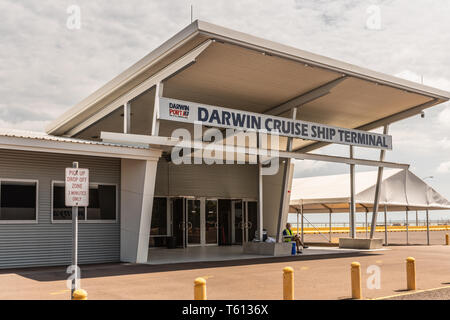 Darwin Australia - February 22, 2019: Entrance to cruise terminal in the harbour under gray cloudscape with yellow vest guard in front. Stock Photo