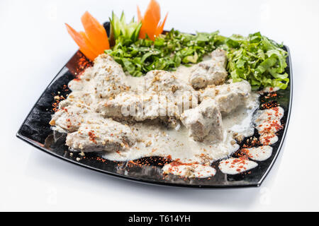 Gedlibzhe - kabardian chicken in sour cream sauce with onion garlic and spices in a frying pan close up. Stock Photo