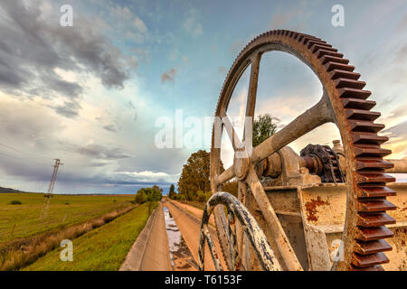 Close-up of a corroded cogwheel with a nice background of clouds. Stock Photo