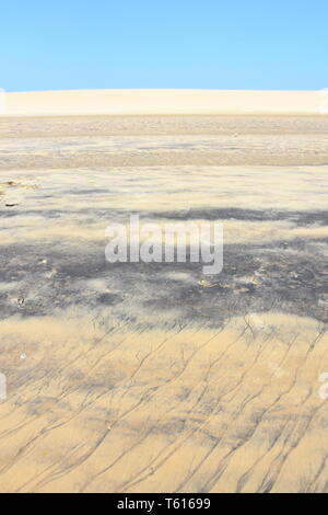 Dark striped ripple pattern made from sand and water on a sand dune Stock Photo