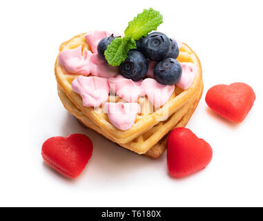 Stack  of heart shaped waffles with pink cream and blueberry isolated on white Stock Photo