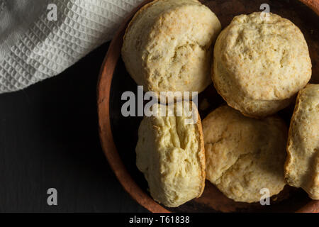 Buttermilk biscuits - scones in earthenware plate close up on black background - top view photograph Stock Photo