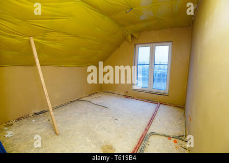 Empty room in a house under construction with fresh screed and plaster Stock Photo