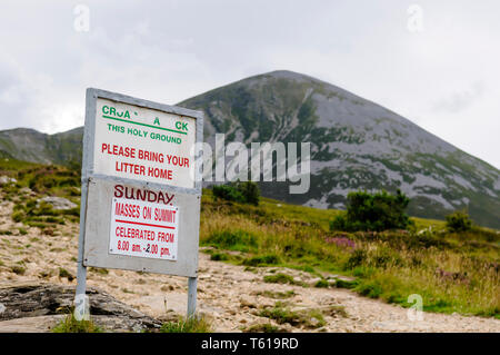 Anti litter sign at foot of Croagh Patrick, with sign for mass on Sunday Stock Photo