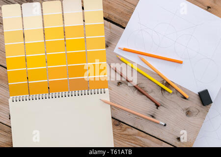 Orange shades used in the design, creation, work. Are placed on a desk with colored pencils. Blank notebooks can put text or images for use as adverti Stock Photo