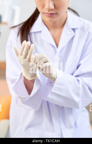 Dentist putting on professional rubber gloves Stock Photo
