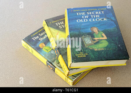 Three Nancy Drew mystery books by Carolyn Keen stacked and fanned out, with The Secret of the Old Clock on top. Stock Photo
