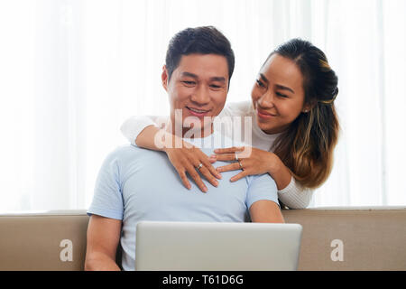 Happy family watching videos on laptop Stock Photo