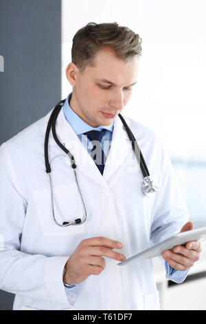 Doctor man using tablet computer for network research or virtual disease treatment. Perfect medical service in clinic. Modern medicine, medic data and Stock Photo