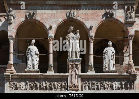 Cremona, il Duomo, facciata, Loggia sopra il protiro del Portale Maggiore: Madonna con Bambino tra i santi Omobono e Imerio Vescovo; fregio marmoreo d Stock Photo