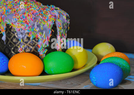Beautiful Easter composition with Easter cake and painted eggs on wooden table. Copy space. Stock Photo
