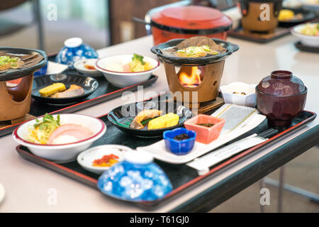 Japanese morning food set; salmon, oak / oba, mini strove, rice, tamago sponge, miso soup, ham salad, side dish, and pickles. Stock Photo