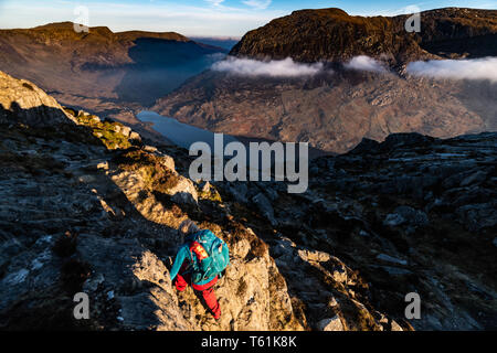 person scrambling climbing welsh mountain try fan in the early morning light Stock Photo