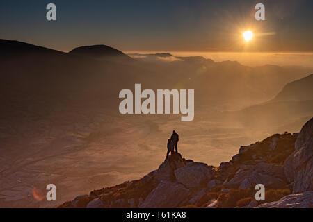 person scrambling climbing welsh mountain try fan in the early morning light Stock Photo