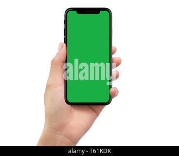 Isolated human left hand holding black mobile smartphone with green screen Stock Photo