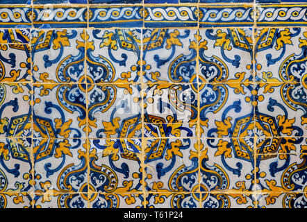 Antique floral decorated Azulejo ceramic tiles in yellow, white and blue colours on wall inside a church, Evora, Alto Alentejo, Portugal, southern Eur Stock Photo