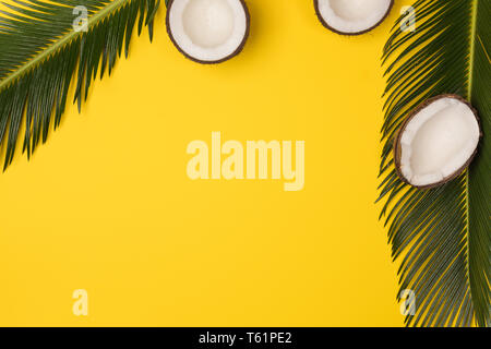 coconuts and palm leaves isolated on yellow background, top view Stock Photo