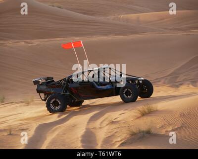 Desert buggy drives action-packed over desert dunes Stock Photo