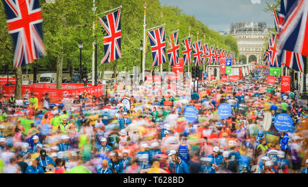 London, UK. 28th Apil 2019. Thousands of runners walk along the Mall, relieved to have crossed the finish line. (Long Exposure) Over 40,000 starters are once again competing in the Virgin London Marathon, including those who take on the race for charities, in running clubs, in memory of loved ones and as personal lifetime goals. Credit: Imageplotter/Alamy Live News Stock Photo