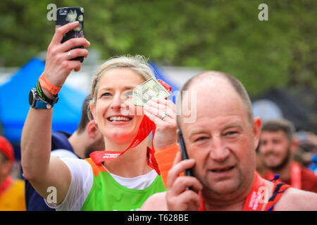 London, UK. 28th Apil 2019. Selfie time! A participant takes a photo with her medal. Over 40,000 starters are once again competing in the Virgin London Marathon, including those who take on the race for charities, in running clubs, in memory of loved ones and as personal lifetime goals. Credit: Imageplotter/Alamy Live News Stock Photo