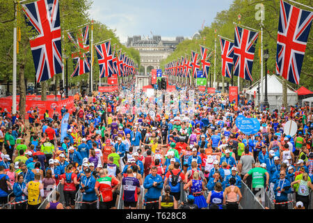 London, UK. 28th Apil 2019. Thousands of runners walk along the Mall, relieved to have crossed the finish line. Over 40,000 starters are once again competing in the Virgin London Marathon, including those who take on the race for charities, in running clubs, in memory of loved ones and as personal lifetime goals. Credit: Imageplotter/Alamy Live News Stock Photo
