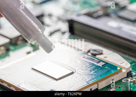 A tube of thermal grease over the processor chip. Part of laptop Stock Photo