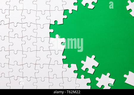 White jigsaw puzzle on green background Stock Photo