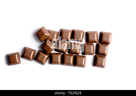 Scattered milk chocolate dice top view from above - Randomly close up pieces of chocolate bar isolated on white background flat lay viewed from above Stock Photo