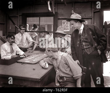 1890s 1900s 1910s FARO CARD GAME MEN PLAYING GAMBLING IN OLD WILD WEST SALOON silent movie still uncorrected glass plate - asph106 ASP001 HARS WILD WEST LIFESTYLE ACTOR HISTORY STUDIO SHOT COPY SPACE HALF-LENGTH PERSONS DANGER MALES RISK WESTERN ENTERTAINMENT DEALER ACTING PLAYERS B&W MOVIES COWBOYS FREEDOM GAMBLING LUCK POKER TURN OF THE 20TH CENTURY CHOICE DRAMATIC EXCITEMENT LUCKY FILM STILLS IN OF SALOON FILM STILL UNLUCKY ACTORS DRAMA GAMBLE SILENT MOVIE GAMBLERS MOTION PICTURE PUBLICITY STILL STILLS MOVIE STILL BET BLACK AND WHITE CAUCASIAN ETHNICITY CHANCE OLD FASHIONED Stock Photo