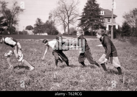 1920s 1930s GROUP OF EXUBERANT PRETEEN BOYS WEARING PLUS FOURS AND KNEE SOCKS PLAYING TOUCH FOOTBALL IN SUBURBAN GRASS FIELD - b1819 HAR001 HARS ACTIVITY PASSING HAPPINESS PHYSICAL LEISURE STRENGTH STRATEGY EXCITEMENT EXTERIOR LEADERSHIP IN OF PRETEEN KNEE SOCKS CONCEPTUAL FLEXIBILITY MUSCLES STYLISH PLUS FOURS PRE-TEEN PRE-TEEN BOY TOGETHERNESS BLACK AND WHITE CAUCASIAN ETHNICITY EXUBERANT HAR001 OLD FASHIONED Stock Photo