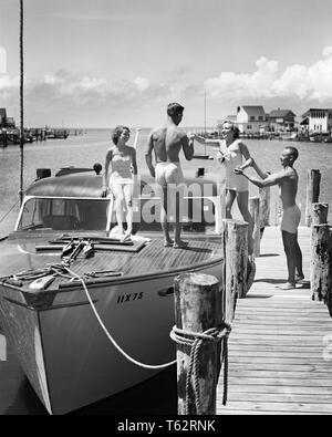 1940s 1950s TWO YOUNG COUPLES MEN WOMEN WEARING BATHING SUITS BOARDING SMALL CABIN CRUISER POWER BOAT MOORED BAY SIDE AT DOCK - b5270 HAR001 HARS LIFESTYLE FEMALES MARRIED RURAL SPOUSE HUSBANDS HEALTHINESS LUXURY COPY SPACE FRIENDSHIP FULL-LENGTH LADIES PERSONS DOCK MALES CONFIDENCE TRANSPORTATION B&W PARTNER TIME OFF SKILL ACTIVITY AMUSEMENT HAPPINESS ADVENTURE HOBBY LEISURE TRIP INTEREST GETAWAY EXCITEMENT HOBBIES KNOWLEDGE RECREATION PASTIME PLEASURE AT HOLIDAYS NJ POWER BOAT CONCEPTUAL BOATING STYLISH NEW JERSEY BATHING SUIT RELAXATION SEASHORE TOGETHERNESS VACATIONS WIVES YOUNG ADULT MAN Stock Photo