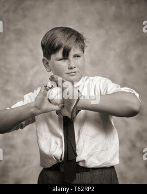 1930s BOY WITH GLOVE AND BASEBALL GETTING READY TO PITCH OR THROW - b5500 HAR001 HARS FOCUS B&W PITCHER STRENGTH STRATEGY AND RECREATION WHITE SHIRT NECKTIE PITCH OR BALL GAME BALL SPORT FOCUSED JUVENILES PRE-TEEN TOSS BASEBALL BAT BLACK AND WHITE CAUCASIAN ETHNICITY CONCENTRATION FRECKLE-FACED HAR001 OLD FASHIONED Stock Photo