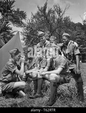 1950s GROUP OF 5 BOY SCOUTS POSING FOR ANOTHER SCOUT KNEELING TAKING PHOTO WITH CAMERA - b6238 HAR001 HARS CONNECTION THRIFTY COURTEOUS FRIENDLY HELPFUL KIND REVERENT TRUSTWORTHY ANOTHER COOPERATION LOYAL PRE-TEEN PRE-TEEN BOY TOGETHERNESS BE PREPARED BLACK AND WHITE BRAVE CAUCASIAN ETHNICITY HAR001 OBEDIENT OLD FASHIONED AFRICAN AMERICANS Stock Photo