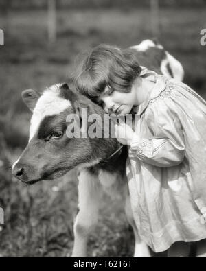 1920s CUTE LITTLE GIRL VISITING DAIRY FARM HUGGING PRESSING HEAD FACE CHEEK TO WARM SOFT NECK OF YOUNG HOLSTEIN CALF - c2267 HAR001 HARS HALF-LENGTH COW INSPIRATION CARING WARM SERENITY CALF CONFIDENCE AGRICULTURE B&W SADNESS CATTLE HAPPINESS STRENGTH RECREATION COWS TO CONNECTION CONCEPTUAL STYLISH VISITING PRESSING GROWTH HOLSTEIN JUVENILES MAMMAL RELAXATION TOGETHERNESS BLACK AND WHITE CAUCASIAN ETHNICITY DOMESTICATED HAR001 LIVESTOCK OLD FASHIONED Stock Photo