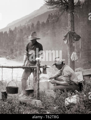 1920s 1930s TWO MEN DUDE RANCH TRAIL GUIDE COWBOYS TOGETHER PREPARING COOKING MEAL OVER CAMPFIRE BRAZEAU RIVER ALBERTA CANADA - c4841 HAR001 HARS COPY SPACE FRIENDSHIP FULL-LENGTH PERSONS MALES WESTERN CAMPFIRE B&W COWBOYS SKILL OCCUPATION SKILLS ADVENTURE CUSTOMER SERVICE KNOWLEDGE OCCUPATIONS CONCEPTUAL DUDE RANCH STYLISH ALBERTA COOPERATION CREATIVITY MID-ADULT MID-ADULT MAN RELAXATION TOGETHERNESS BLACK AND WHITE CAUCASIAN ETHNICITY HAR001 OLD FASHIONED Stock Photo