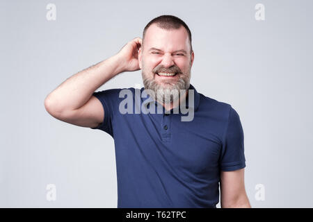 man looking aside scratching head. I have no idea how it happened. Stock Photo
