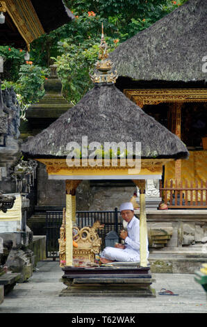 Prayer leader in a small cabin, Pura Tirta Empul temple, Ubud, Indonesia Stock Photo