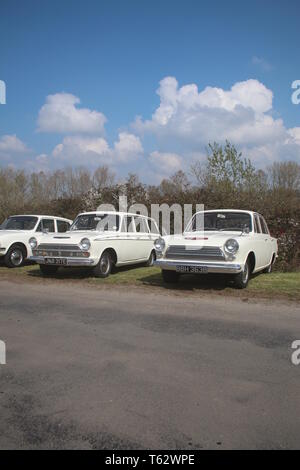 A PAIR OF WHITE CLASSIC FORD CORTINA MARK 1 CARS ONE SALOON AND 1 ESTATE Stock Photo