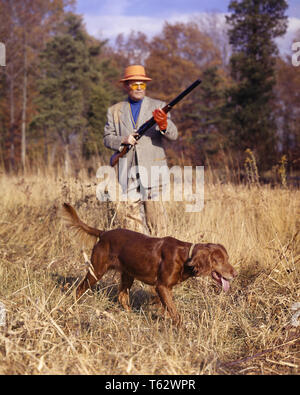 1960s MAN UPLAND GAME BIRD HUNTER WITH TRADITIONAL DOUBLE BARREL SHOTGUN SHOOTING OVER AN IRISH SETTER DOG HOLDING STEADY POINT - kg2771 HAR001 HARS TRADITIONAL MALES HUNTER MIDDLE-AGED MIDDLE-AGED MAN GOALS SKILL ACTIVITY AMUSEMENT HAPPINESS MAMMALS ADVENTURE HOBBY LEISURE STRENGTH INTEREST CANINES EXCITEMENT HOBBIES KNOWLEDGE RECREATION PASTIME SETTER PLEASURE AN POOCH CONNECTION CONCEPTUAL STYLISH SUNLIT UPLAND CANINE FIREARM FIREARMS MAMMAL RELAXATION AMATEUR CAUCASIAN ETHNICITY CRISP DOUBLE BARREL ENJOYMENT GAME BIRD HAR001 OLD FASHIONED Stock Photo