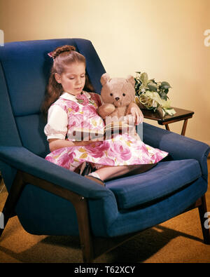 1960s GIRL & TEDDY BEAR NAVY BLUE EASY CHAIR READING A BOOK WEARING PINK WHITE FLORAL DRESS HOUSEPLANT ON END TABLE  - kj3434 FTZ001 HARS OLD TIME BUSY NOSTALGIA READ OLD FASHION 1 TEDDY JUVENILE STYLE FRIEND INFORMATION LIFESTYLE FEMALES FLORAL YOUTHS STUFFED HOME LIFE PEOPLE CHILDREN FULL-LENGTH END PERSONS QUIET INSPIRATION CONFIDENCE HAPPINESS STRENGTH TEDDY BEAR RELAXED EASY CHAIR A ON CONCEPTUAL COMPANION EASY STYLISH YOUNGSTERS END TABLE HOUSEPLANT JUVENILES NAVY BLUE RELAXATION TOGETHERNESS YOUNGSTER CAUCASIAN ETHNICITY OLD FASHIONED Stock Photo