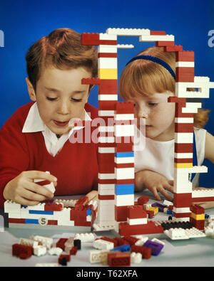 1970s ENTRANCED BOY AND GIRL BROTHER AND SISTER PLAYING TOGETHER WITH LARGE PILE OF PLASTIC LEGO CONSTRUCTION BRICK TOYS  - kj5530 PHT001 HARS SAFETY TEAMWORK JOY LIFESTYLE FEMALES BROTHERS STUDIO SHOT HOME LIFE BRICKS FRIENDSHIP INSPIRATION MALES SIBLINGS CONFIDENCE SISTERS EXPRESSIONS SUCCESS HAPPINESS HEAD AND SHOULDERS DISCOVERY STRENGTH CHOICE KNOWLEDGE REDHEAD INNOVATION SIBLING CONNECTION RED HAIR CONCEPTUAL IMAGINATION STYLISH COOPERATION CREATIVITY GROWTH IDEAS JUVENILES TOGETHERNESS ABSORBED CAUCASIAN ETHNICITY DENMARK OLD FASHIONED Stock Photo