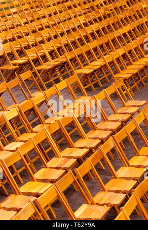 1990s EMPTY WOODEN FOLDING CHAIRS ARRANGED IN ROWS - ks36324 NET002 HARS SYMBOLIC VACANT ALIGN ALIGNED FOLD GONE SEATS OLD FASHIONED RIGID SEVERE Stock Photo