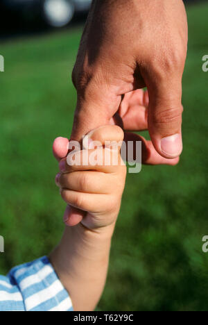 1990s CHILD'S HAND HOLDING MAN'S FINGER CLOSE-UP  - ks36280 BEN004 HARS PERSONS INSPIRATION CARING MALES FATHERS SINGLE PARENT COMFORT SINGLE PARENTS SIZE DADS CONNECTION CLOSE-UP SUPPORT CHILD'S MAN'S ASSIST SYMBOLIC GROWTH JUVENILES MID-ADULT MID-ADULT MAN TOGETHERNESS CAUCASIAN ETHNICITY Stock Photo